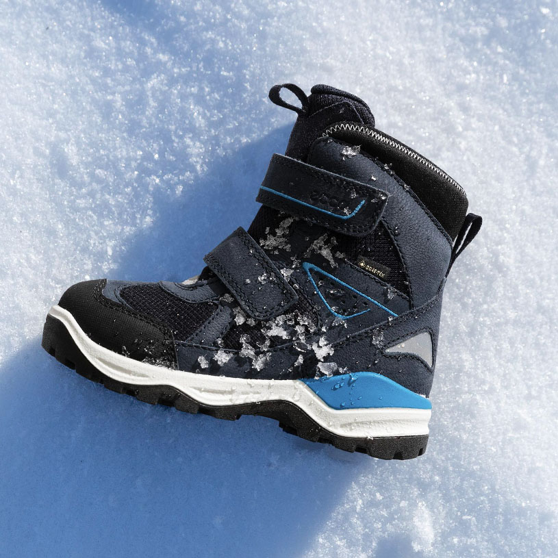 Winterstiefel im Schnee, dunkelblau mit Klettverschluss.