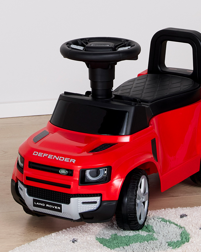 Rotes Spielzeugauto mit Land Rover-Logo, gestaltet als Mini-Fahrzeug.