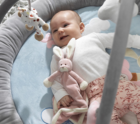 Spielendes Baby unter einem Spielbogen