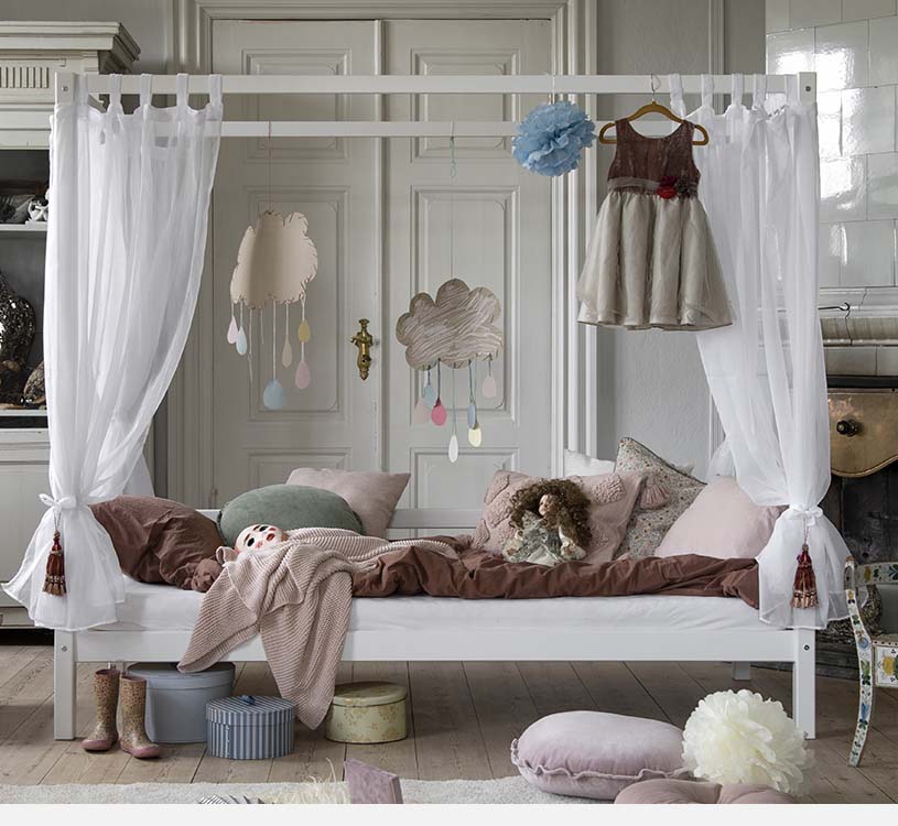 Kinderzimmer mit Himmelbett, weichen Kissen und Spielzeug.