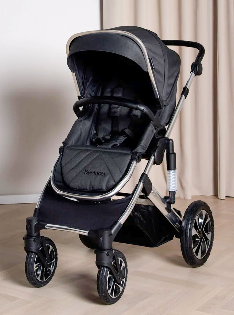Schwarzer Kinderwagen mit großen Rädern in Innenraum.